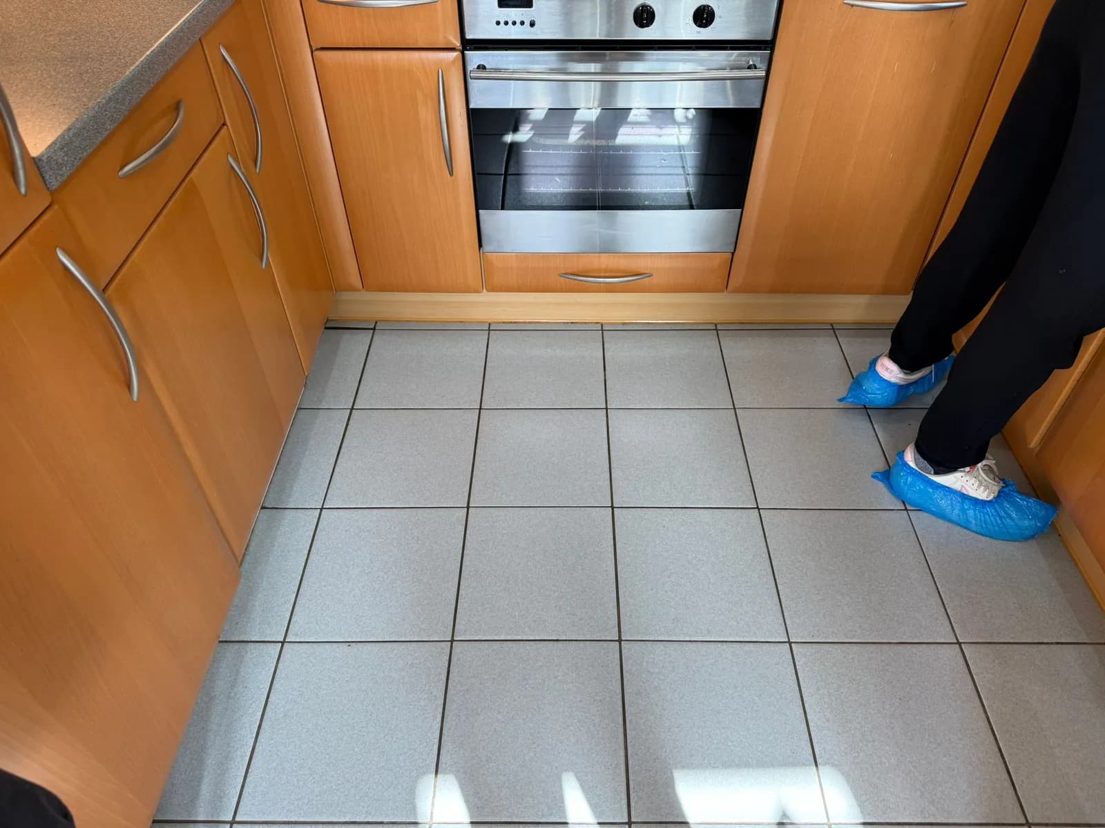 Cleaner wearing protective overshoes in a customer's kitchen