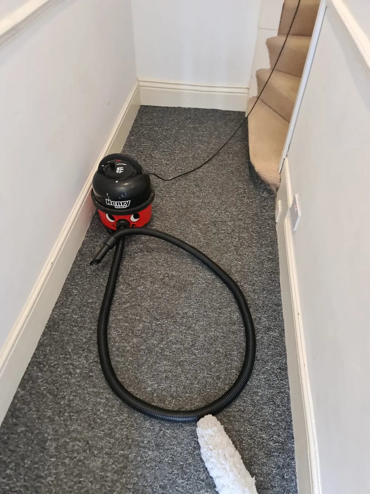 Vacuum cleaner on a carpeted landing during a clean