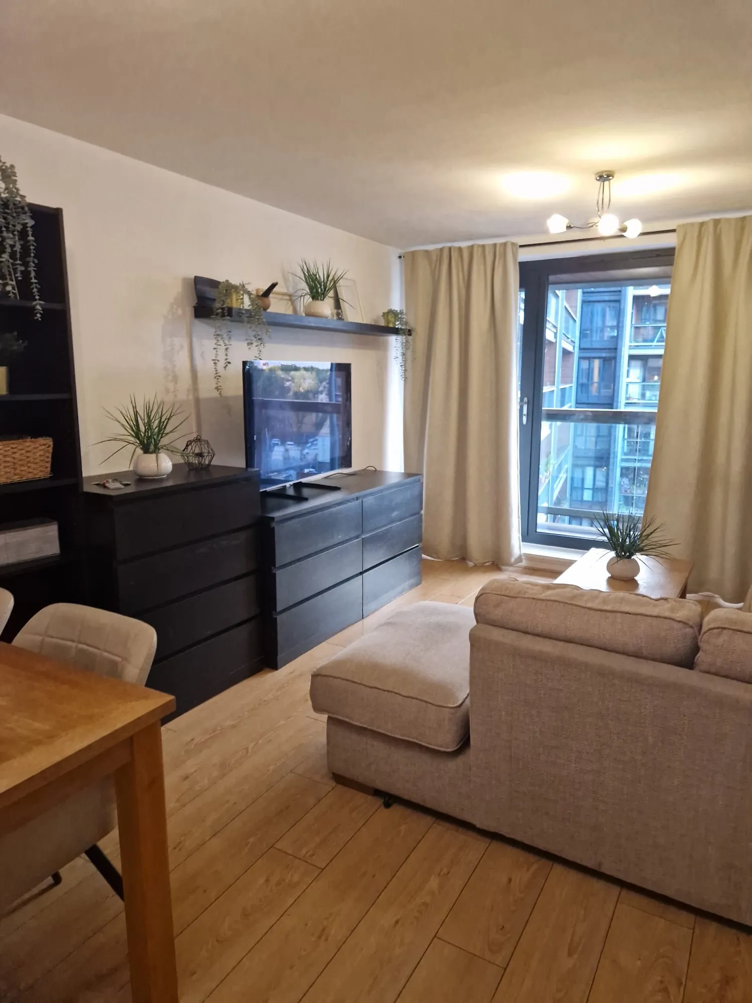 Furnished lounge with sofa and TV after a changeover clean
