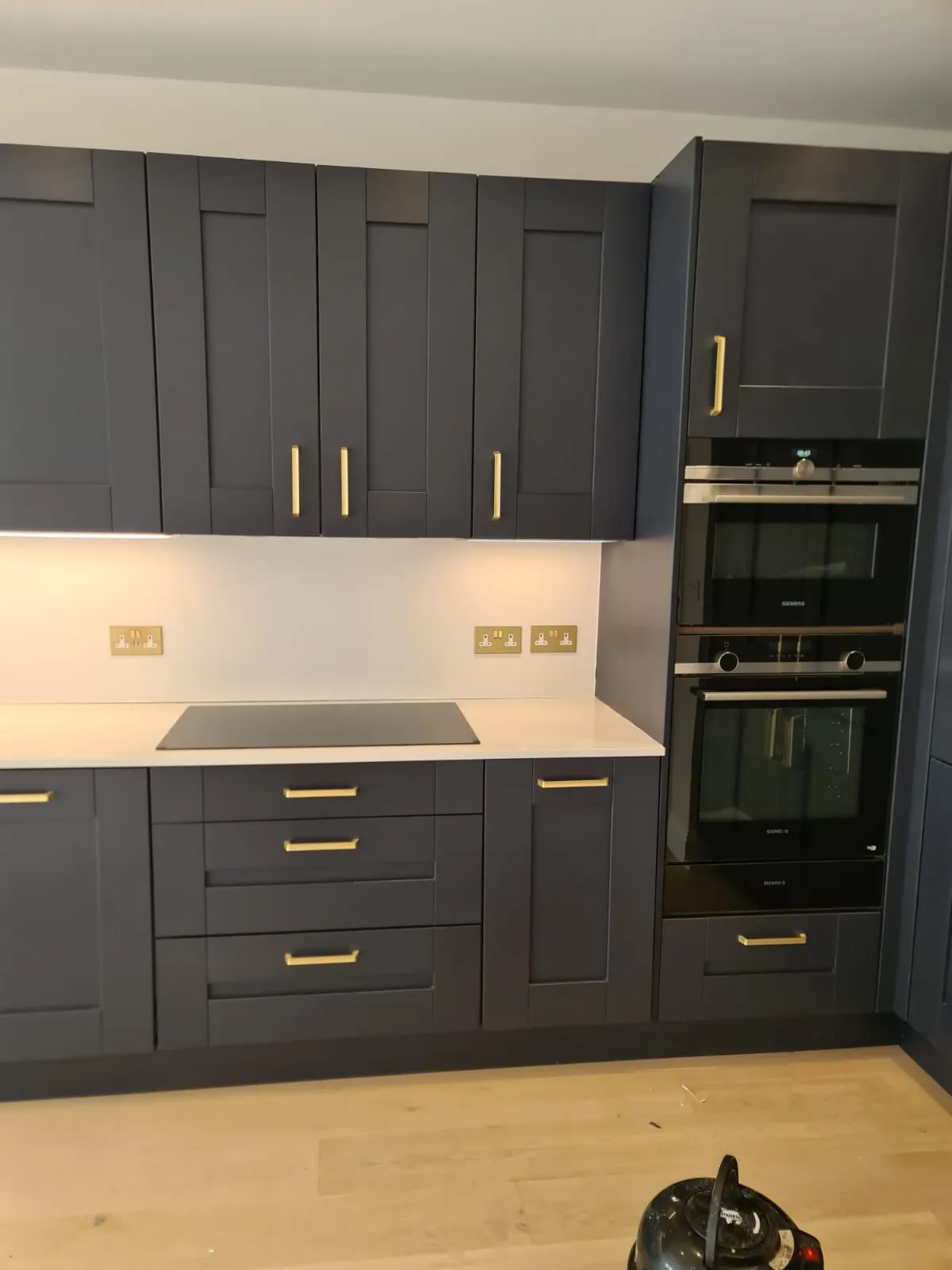 Grey kitchen with built-in ovens after a full clean