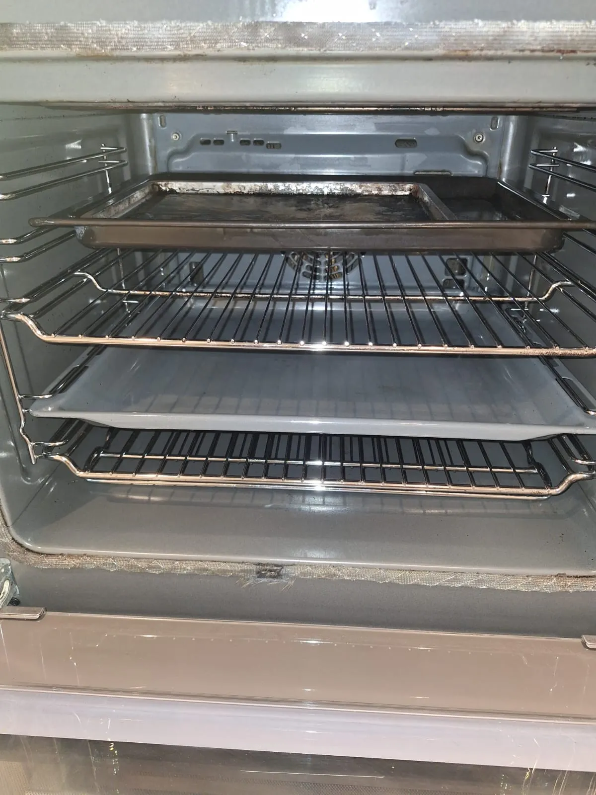 Inside of an oven with racks gleaming after a professional clean